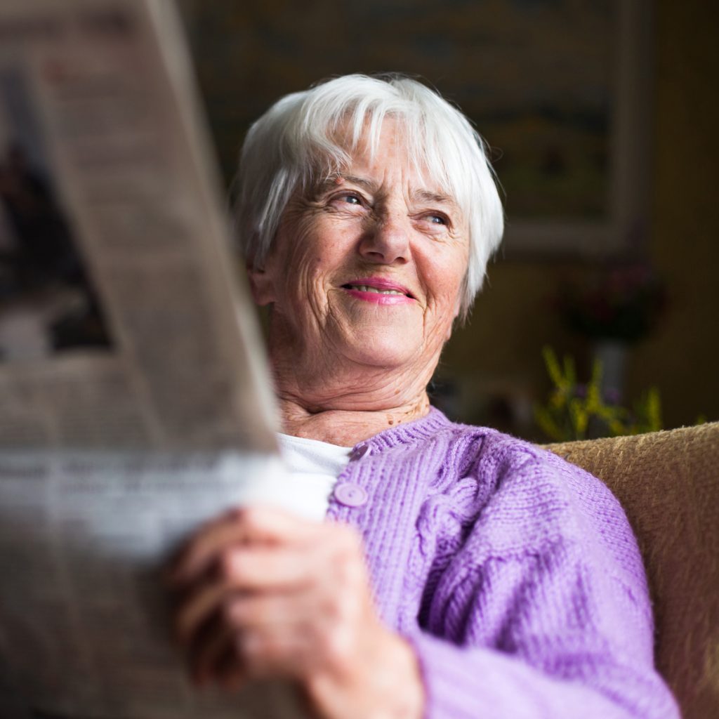 cappella grand junction senior woman reading newspaper