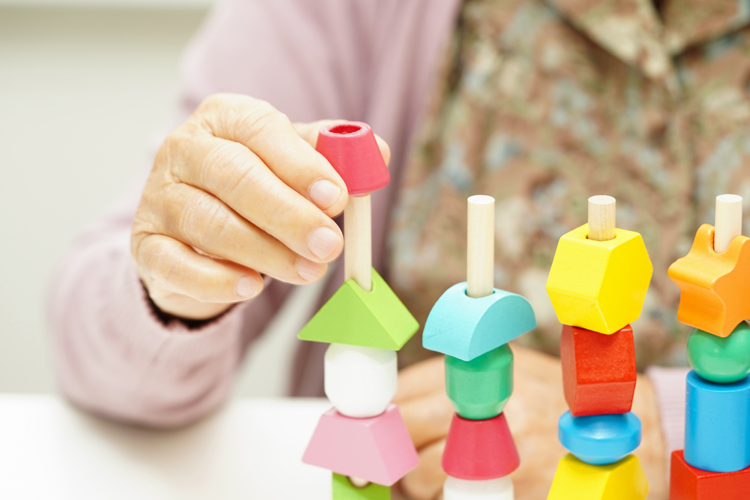 close-up of older woman a placing pieces on pegboard