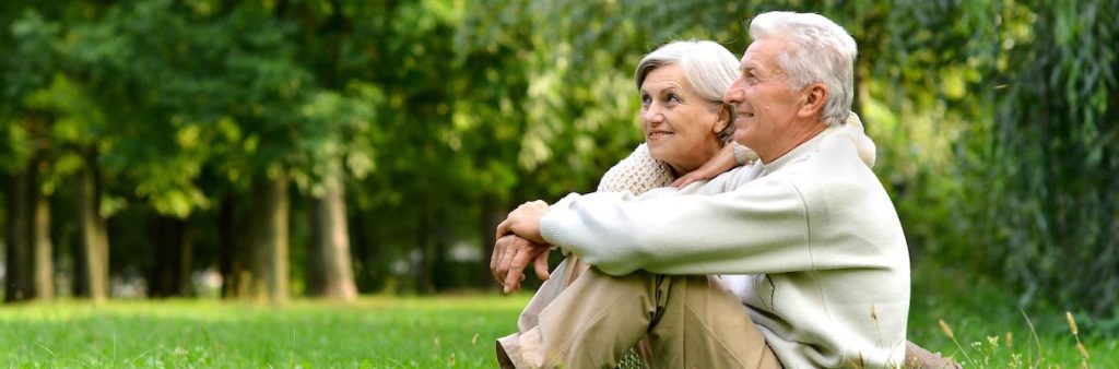 senior couple sitting on grass