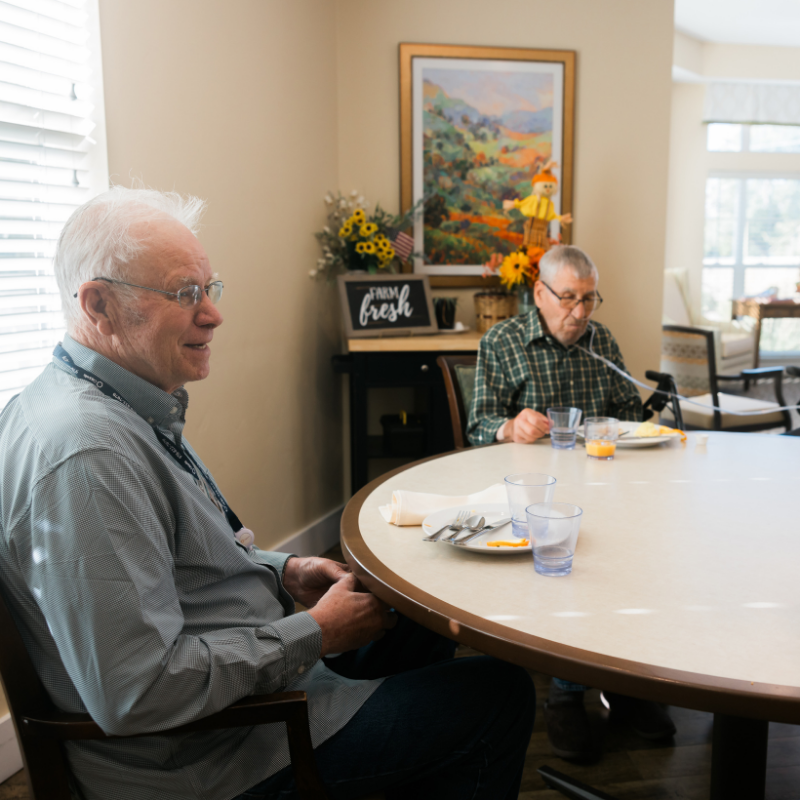 residents sitting at community dining table square