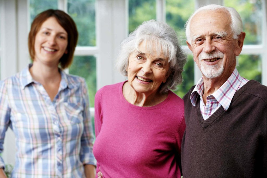 older couple and adult daughter smiling