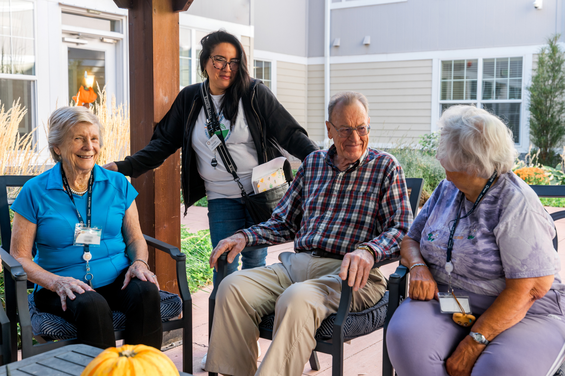 residents and care partner enjoying the fall outside on the pergola 2 landscape