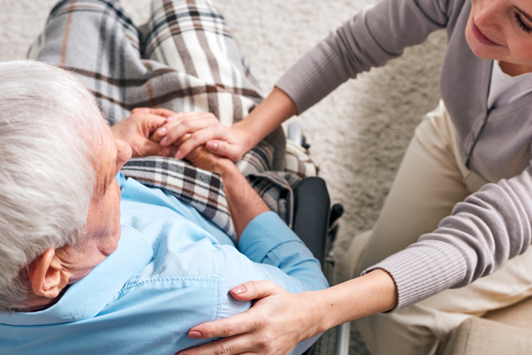 senior man in wheelchair with care partner