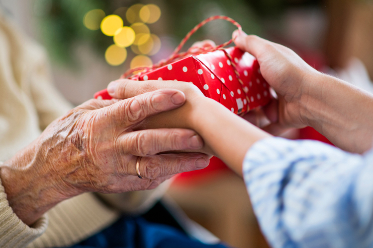 child giving older person gift