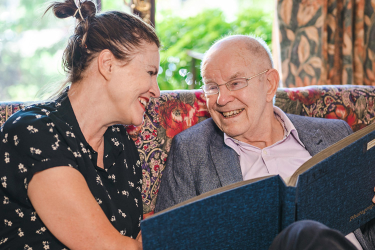 cappella of grand junction senior man and adult daughter looking at photo album